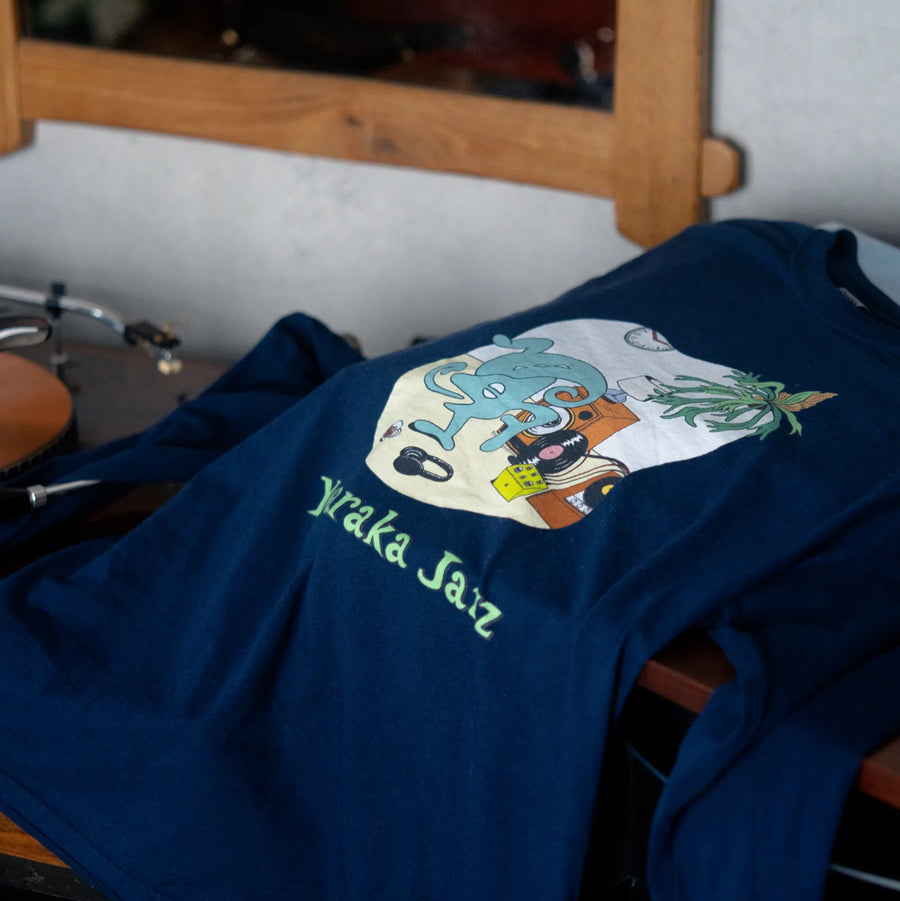 部屋の机に置いた Room Tee（True Navy）（写真は米国で刷る半袖 Room Tee です）
