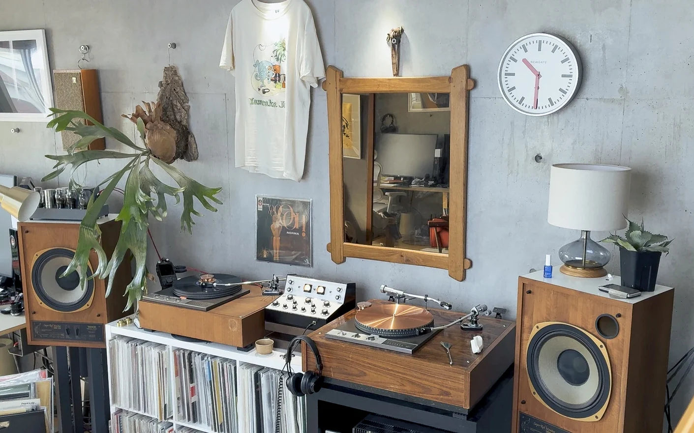 本物の部屋: 2 台のターンテーブル、時計、ランプ、スピーカー、壁に掛けた T シャツ